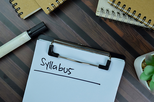 Clipboard with syllabus written in black marker