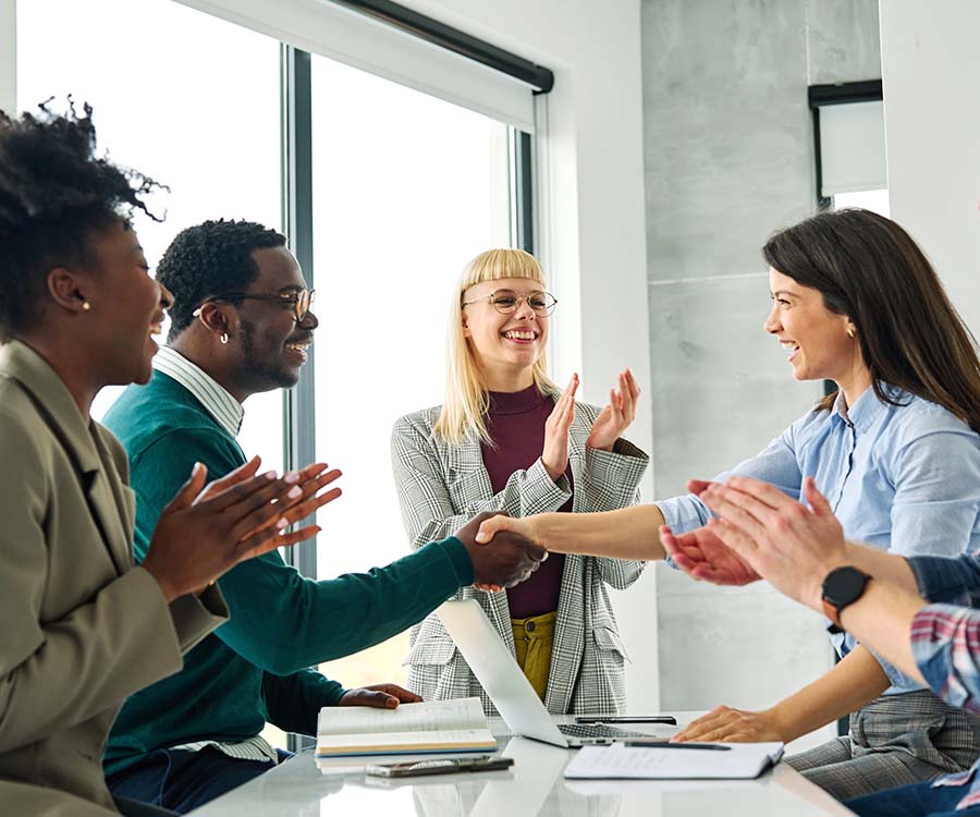 People around a table congratulating each other and clapping