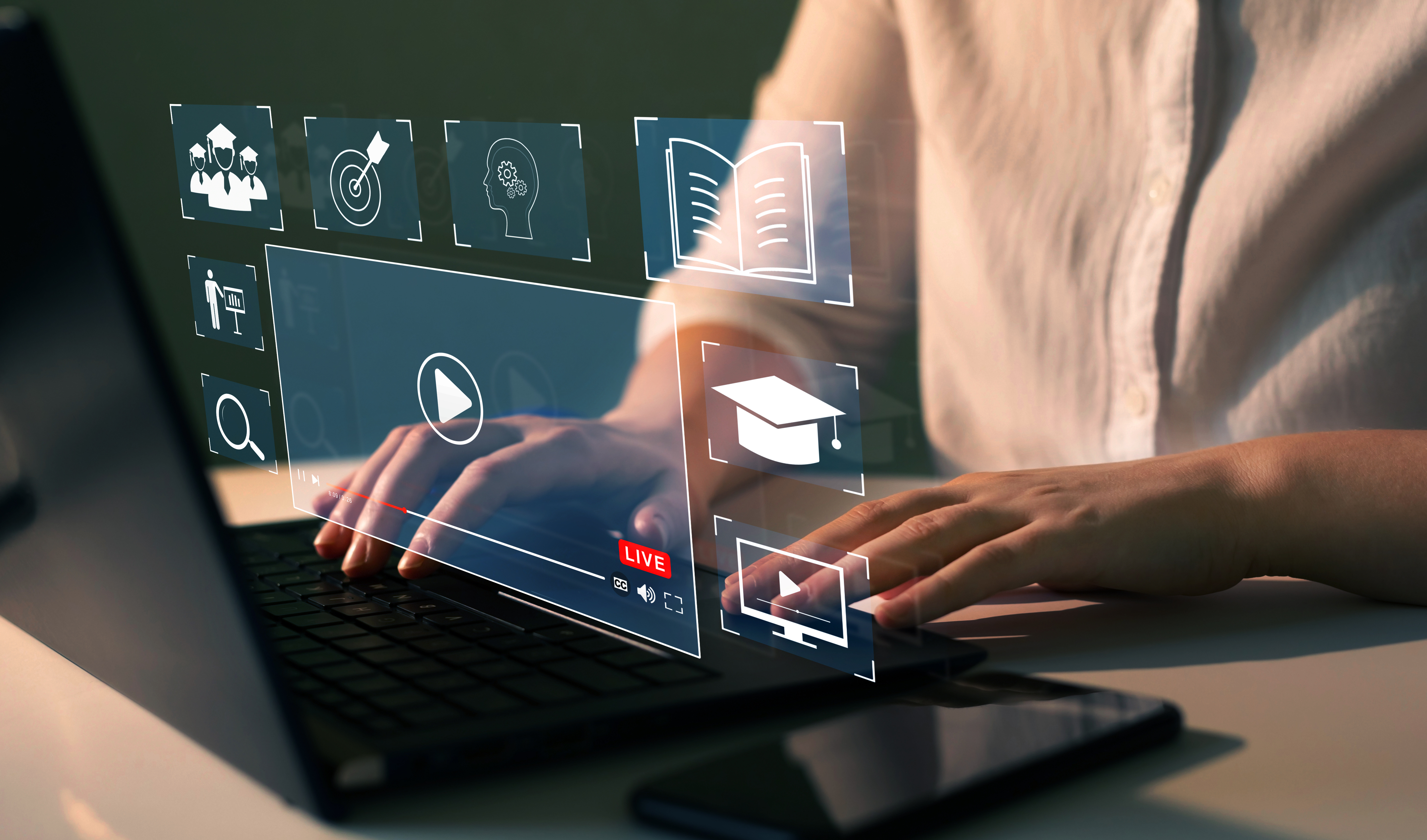 A person at a laptop with icons popping out of the screen