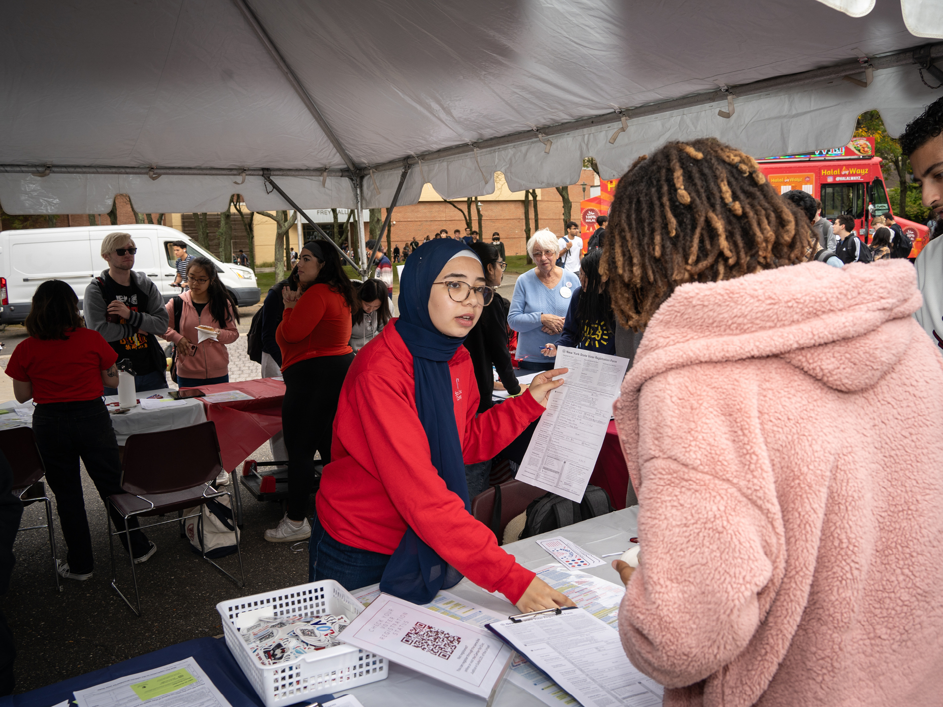 A student teaching another how to fill out election forms.