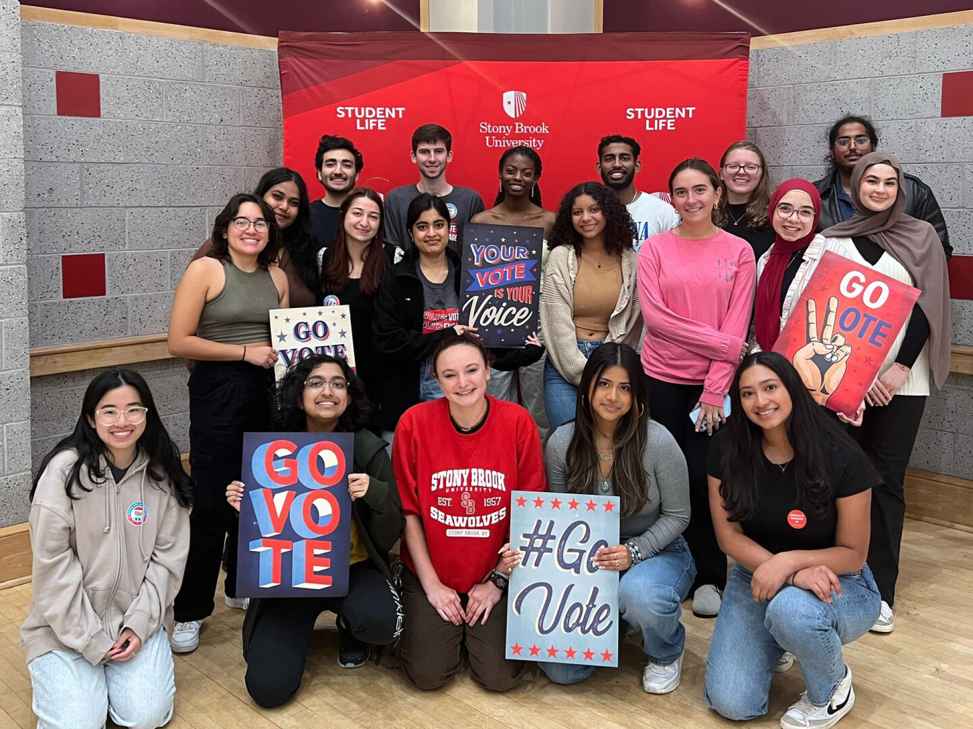 A group of students holding up voting signage.