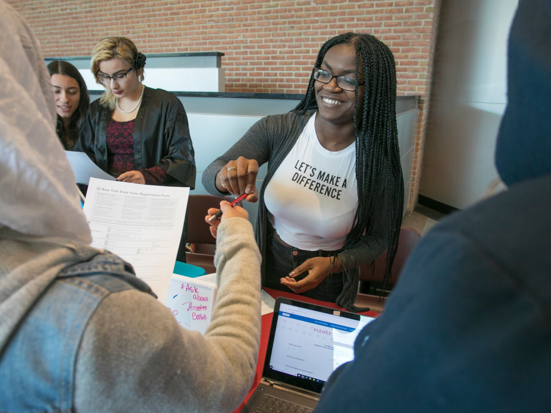 A student helping another fill out voter registration forms.