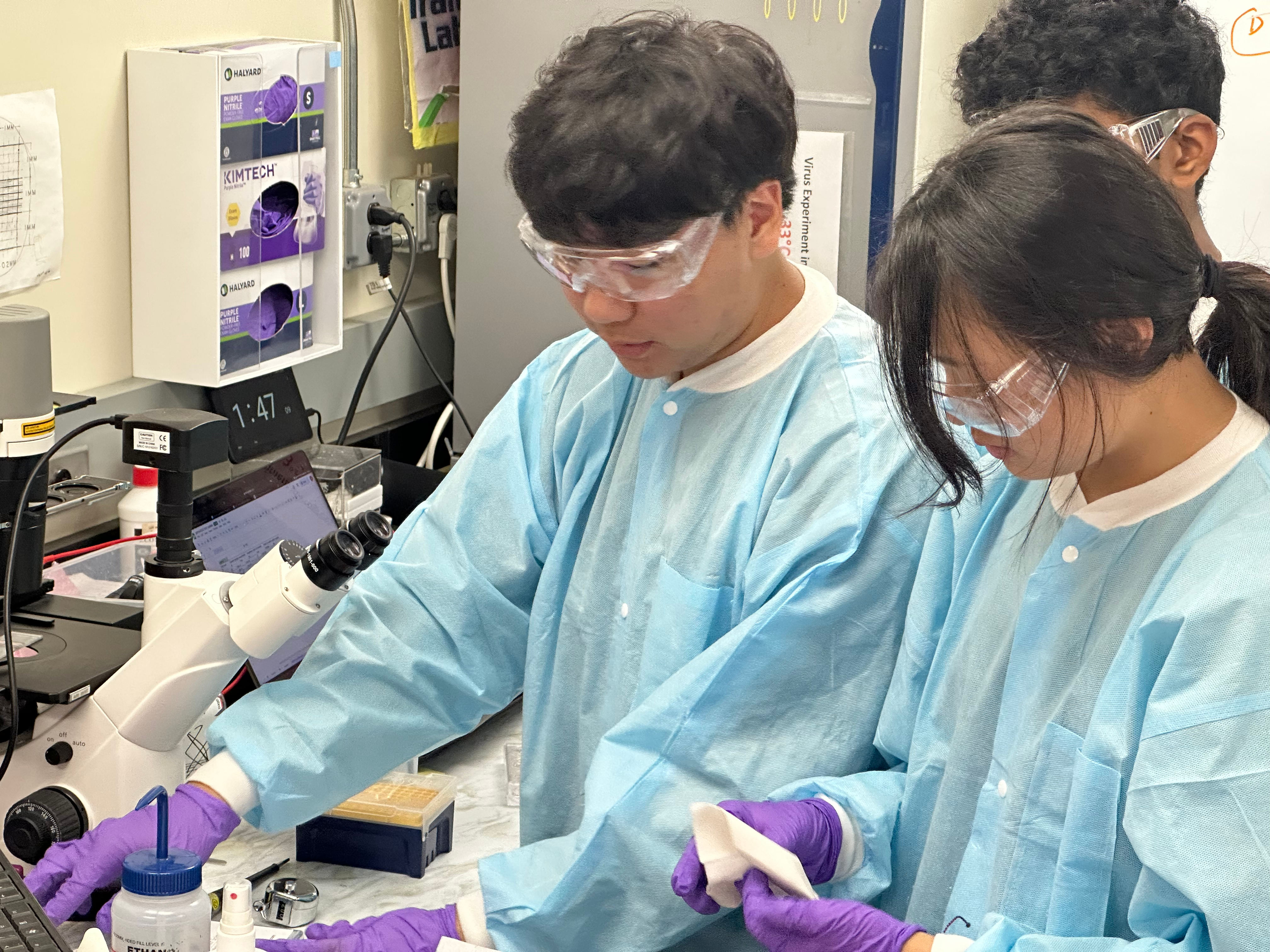 Three students working at lab bench