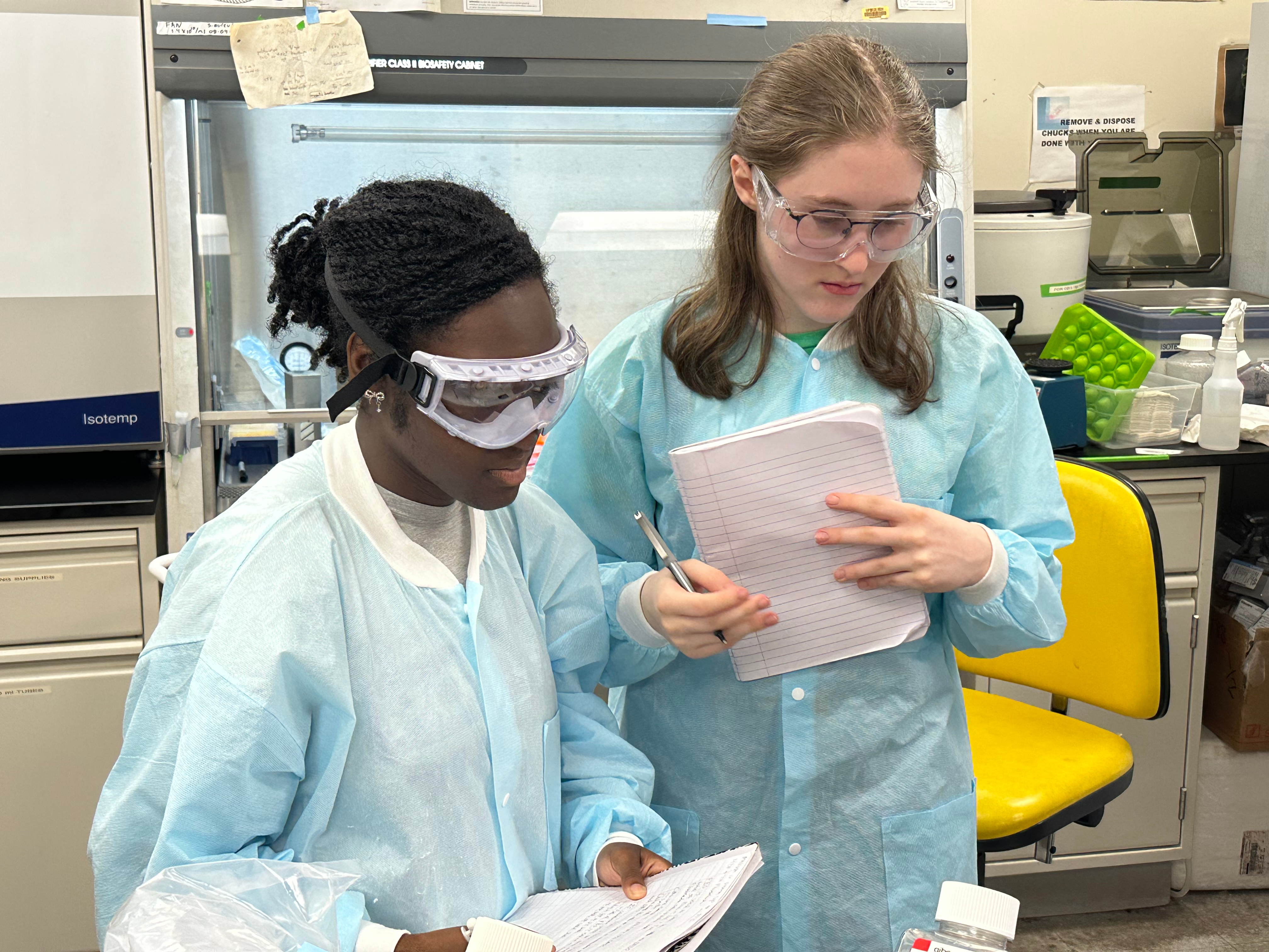 Two students looking down at lab bench