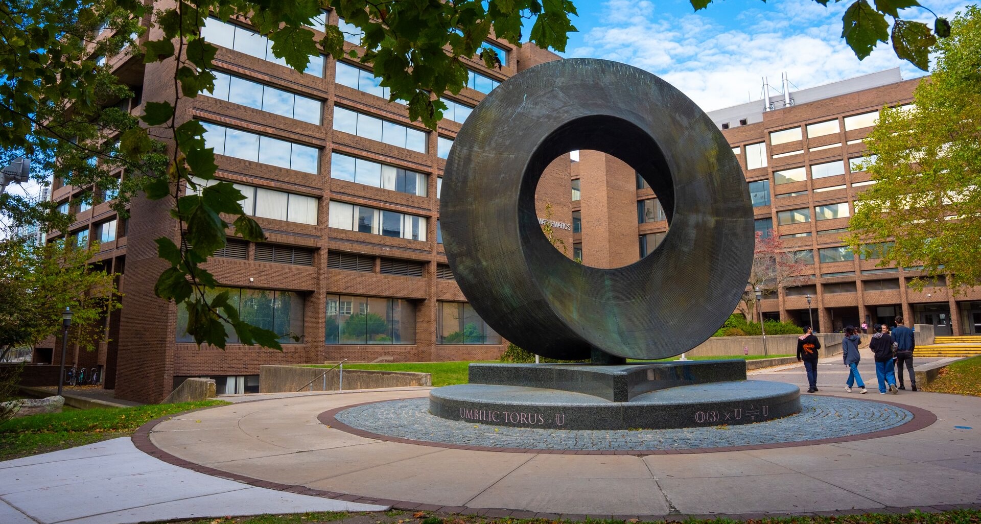 Students walking by the Umbilic Torus sculpture at Stony Brook University