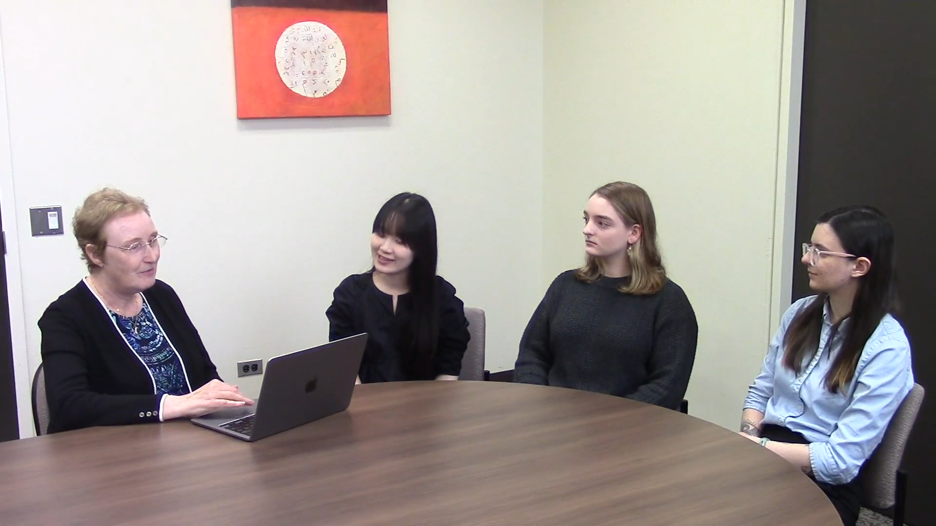 Dr. Patricia Duff with student interns Isabella Birbiglia, Kayo Takahashi, and Melis Tozoglu sitting on round table