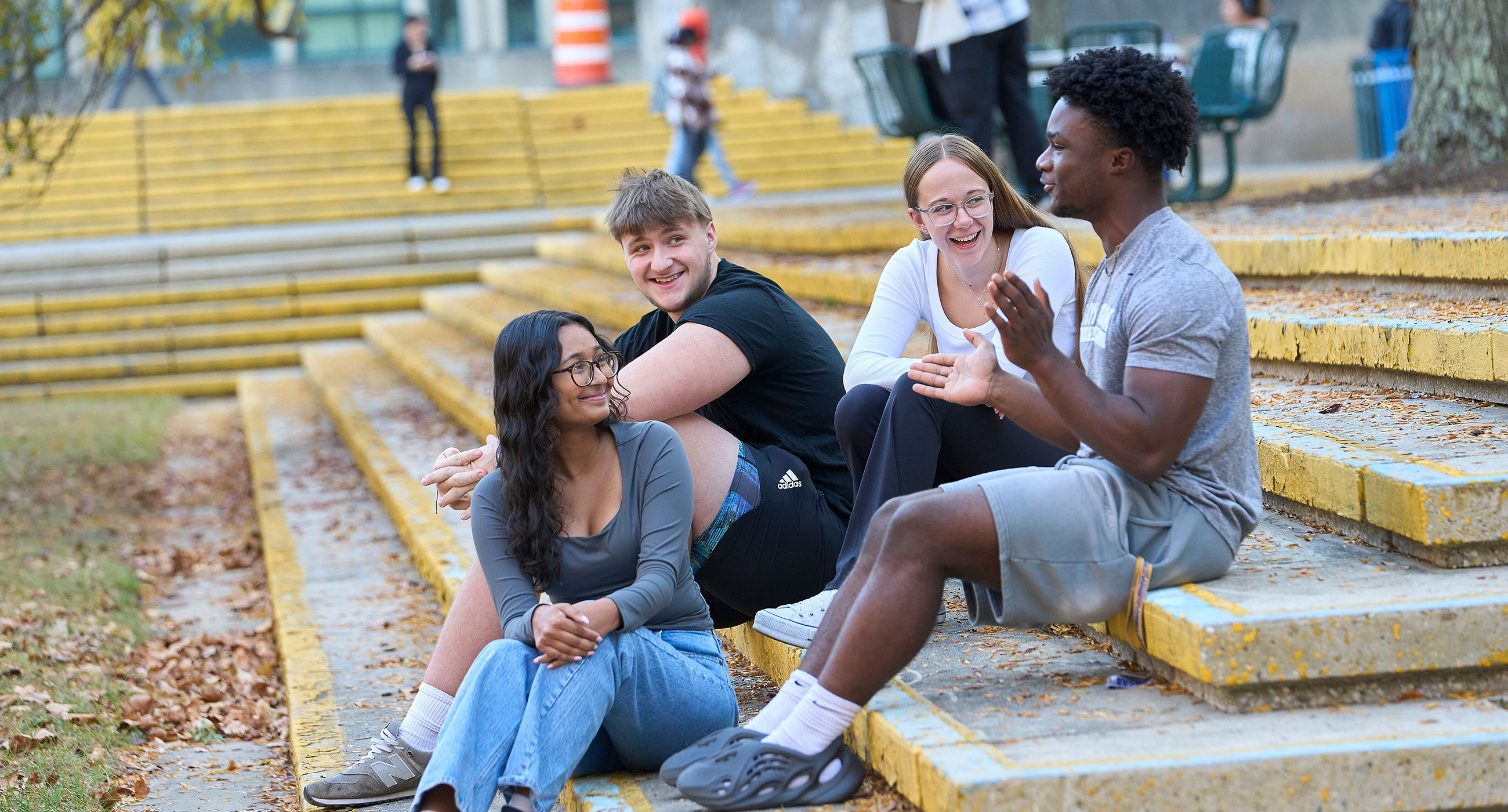 Students sitting on steps interacting and laughing.