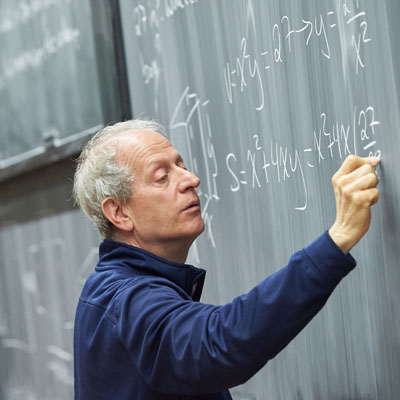 professor writing on chalkboard