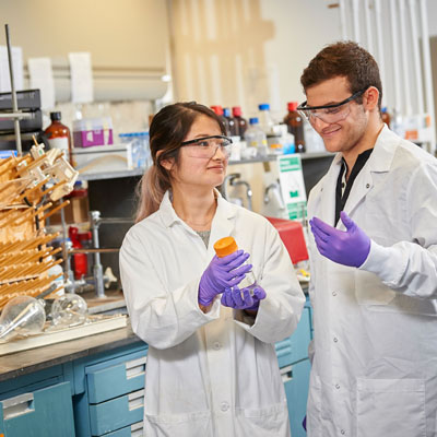 Two laboratory employees collaborating in a research lab representing internal job opportunities