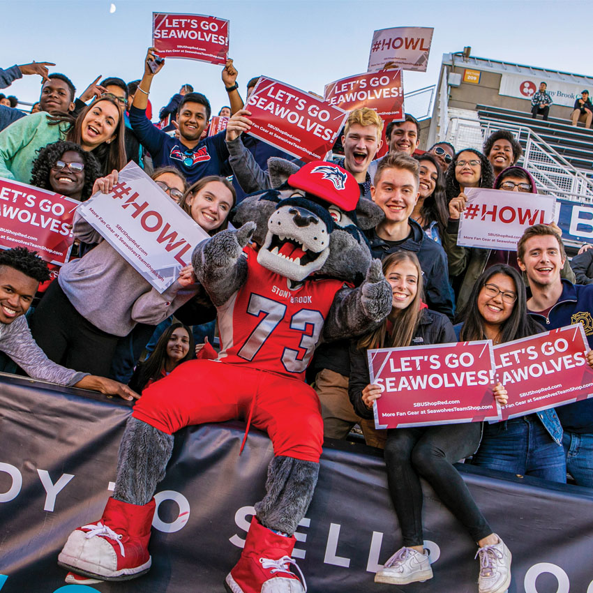Students and mascot cheering together at a campus event