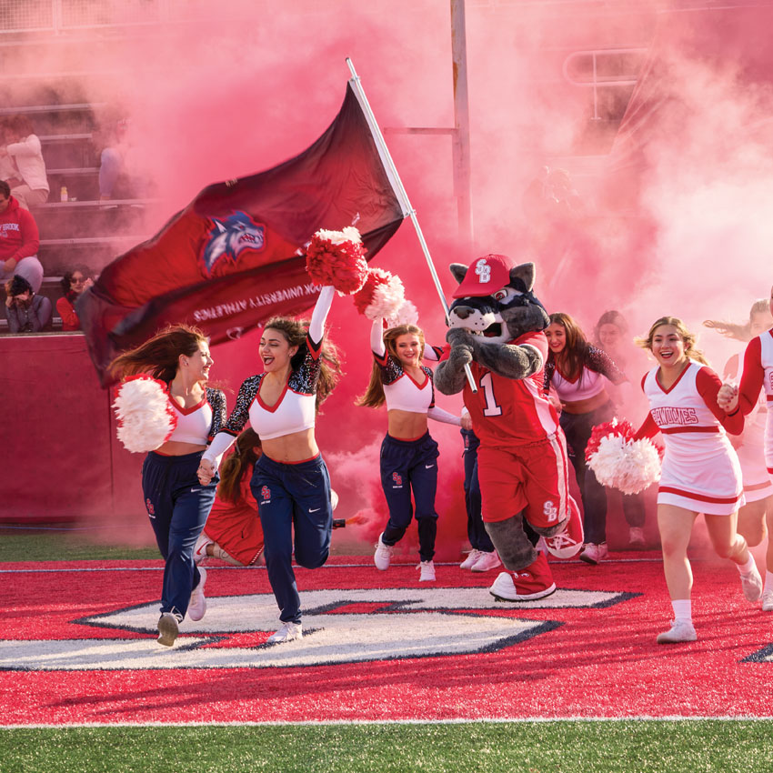 wolfie running with cheerleaders