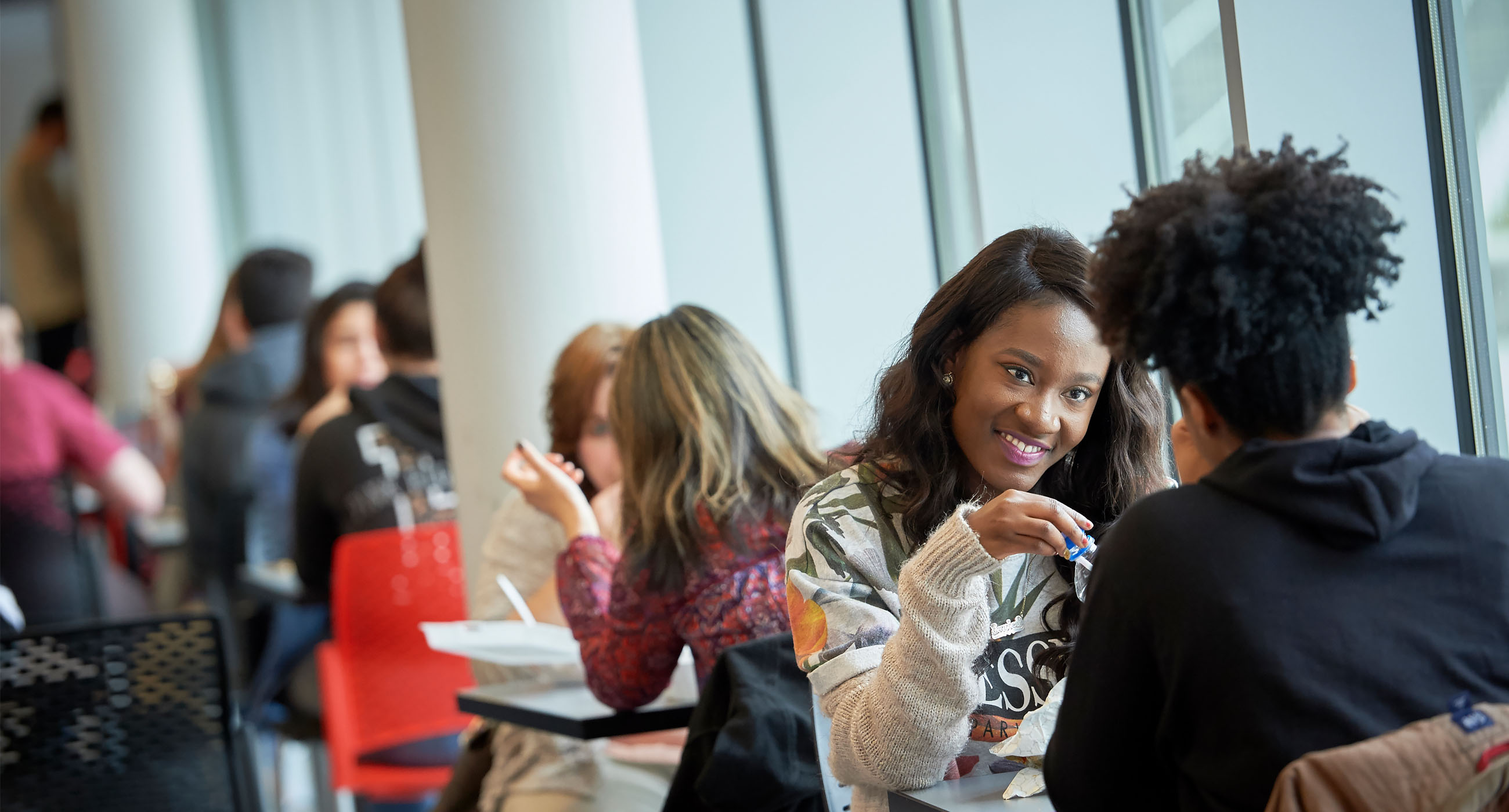 Students sitting around a table chatting with eachother