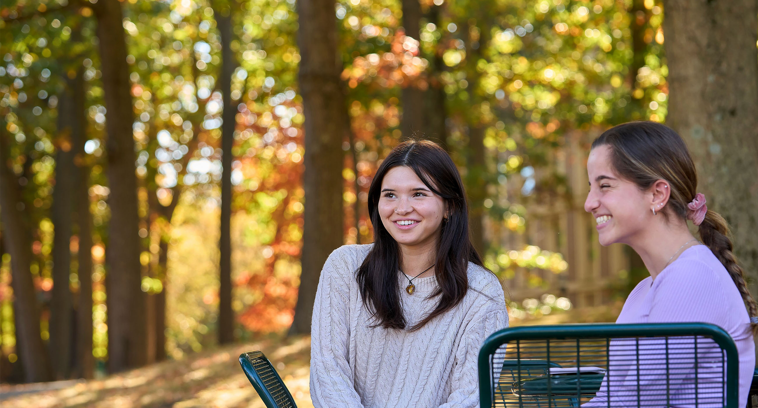 Students sitting around a table smiling