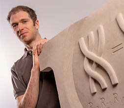 faculty member posing next to abstract 3d image of dna on a board