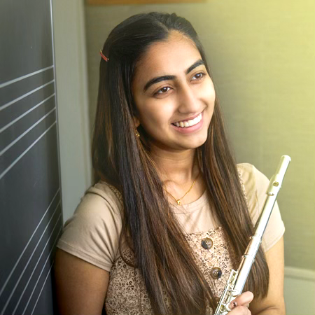 Student playing flute in a practice room