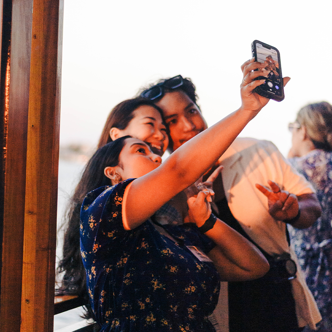 three people taking a selfie on their phone
