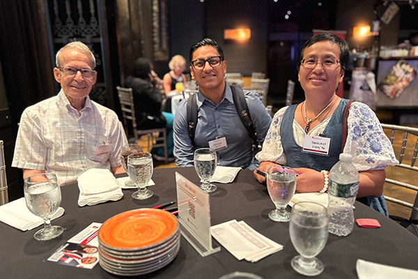 Group of 3 people at table enjoying beverages