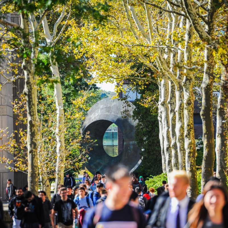 students walking in front of Umbilic Torus