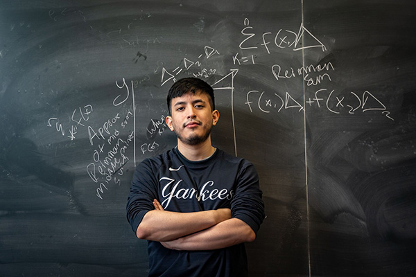 Student standing by chalkboard