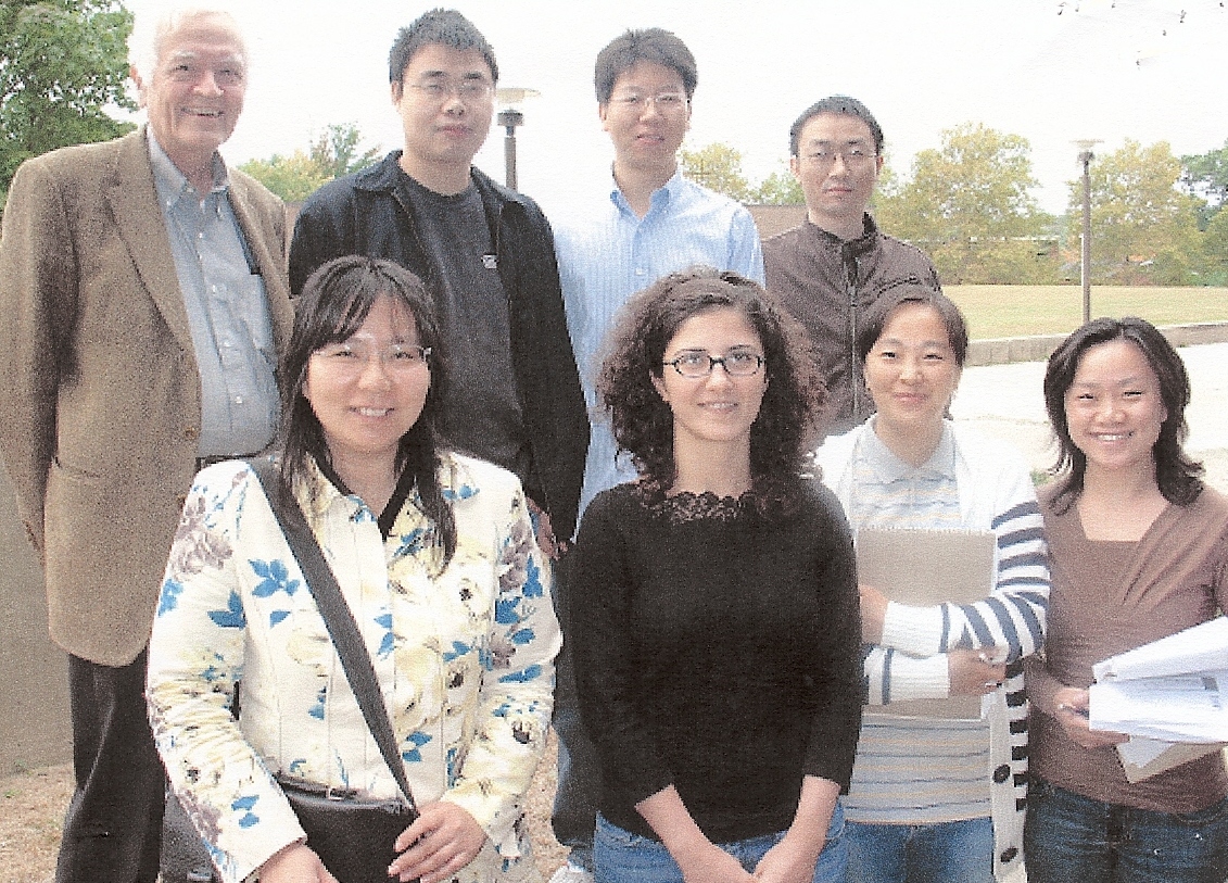 Professor standing with graduate research group outside