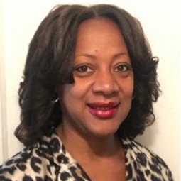 African American woman with curled hair and cheetah print shirt; photo cropped tight to face