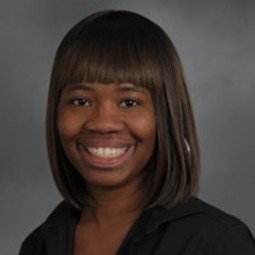 African American woman with shoulder length hair and bangs, black shirt