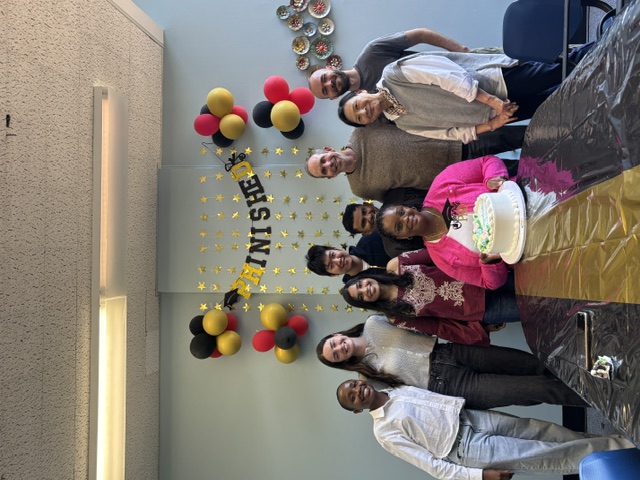 image of a group celebrating with balloons and cake