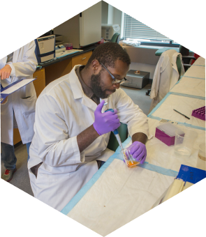 student in labcoat using a pipette