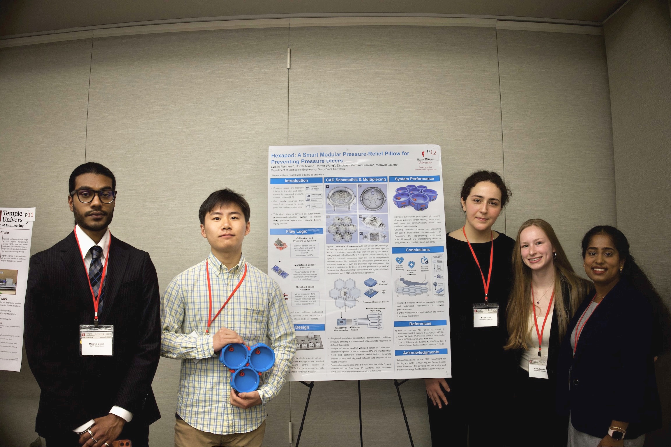 Senior design group posing next to their NEBEC 2026 poster
