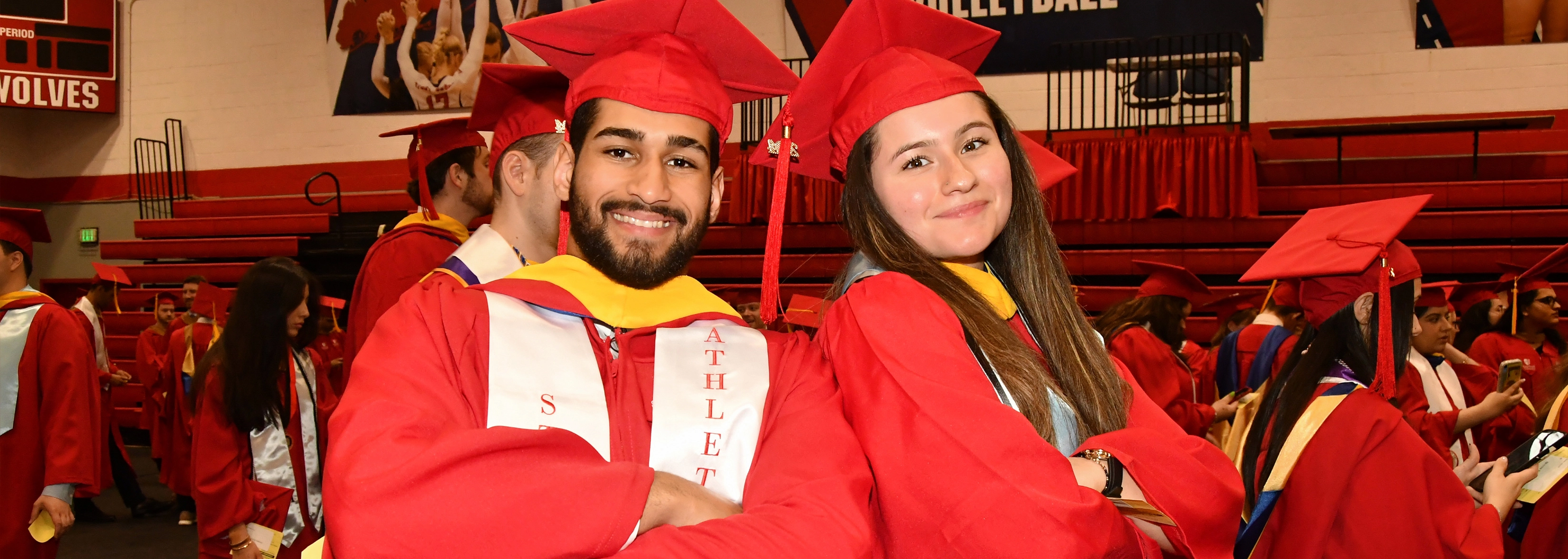 two students in college of business regalia on convocation day