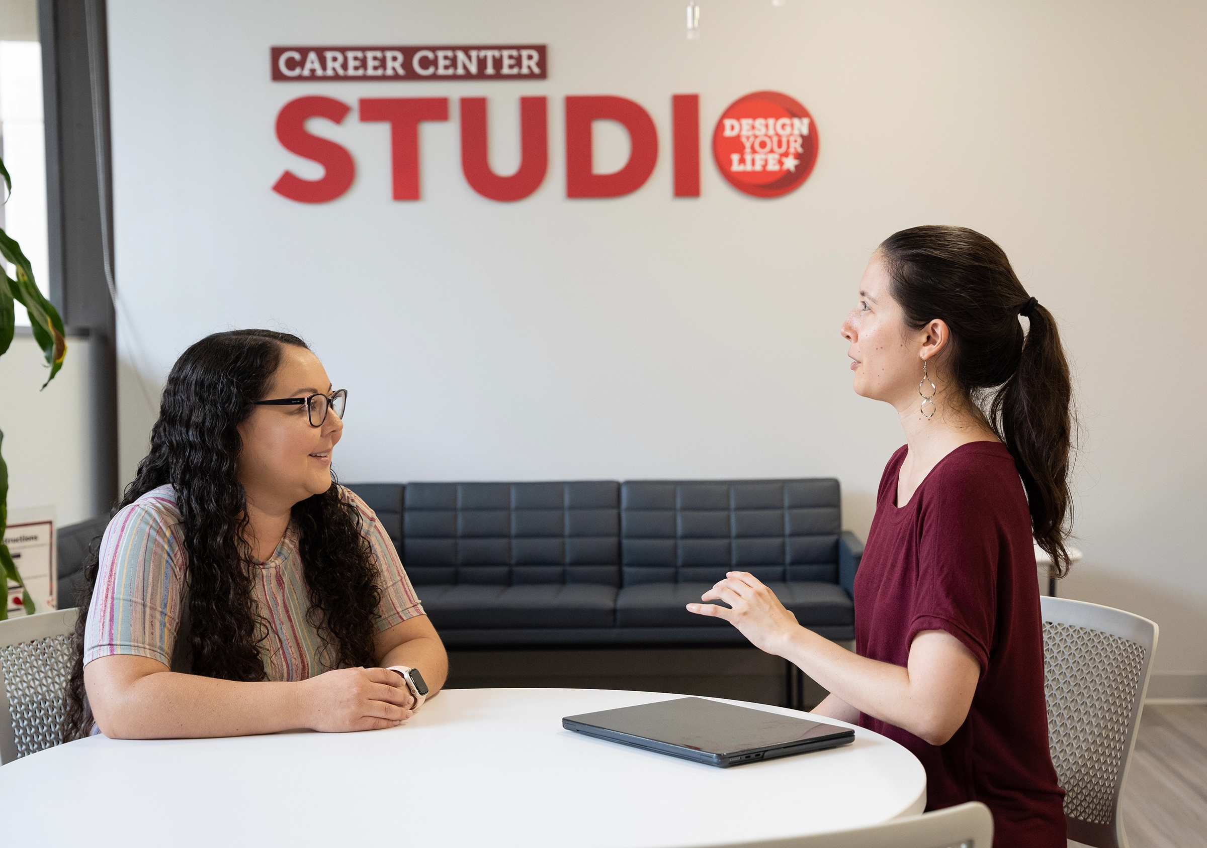 career coach with a student in front of career studio sign