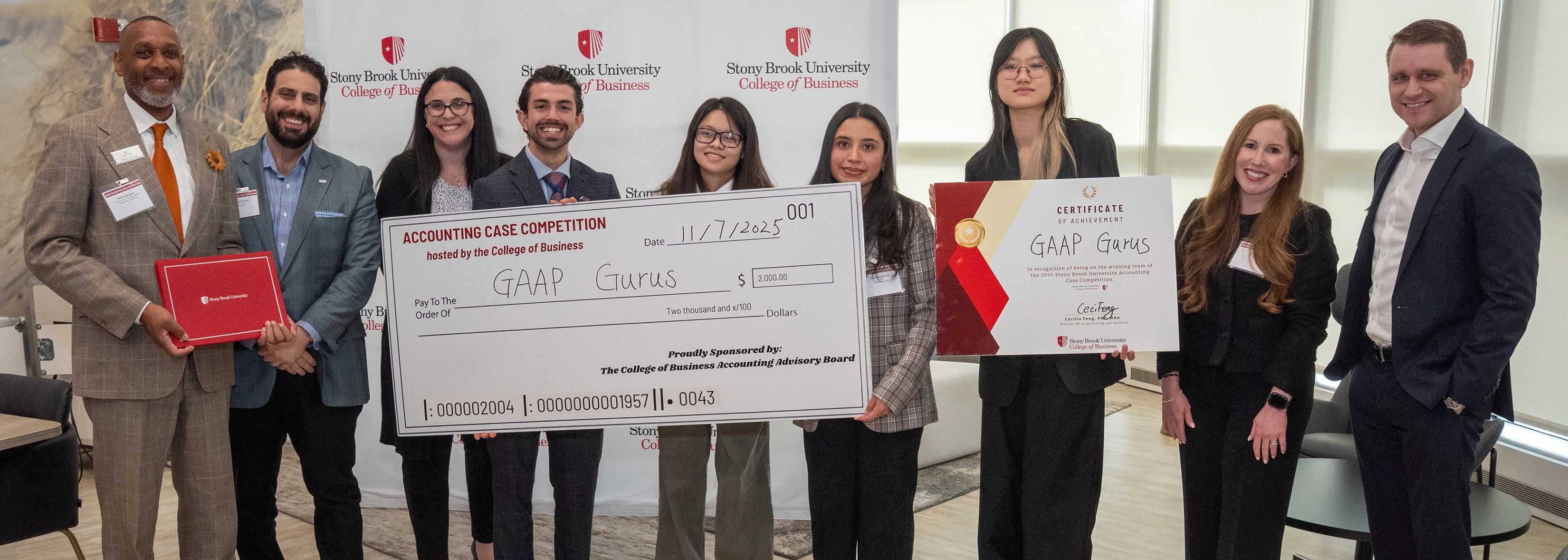 first place winners holding big check group photo