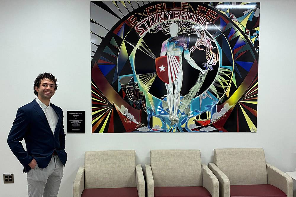 Student artist Ray Lizzol in front of his colorful mural