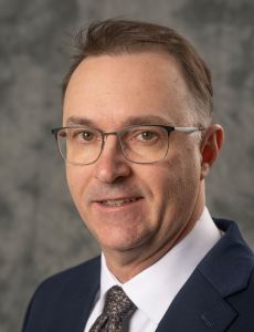 Man in suit and glasses smiling