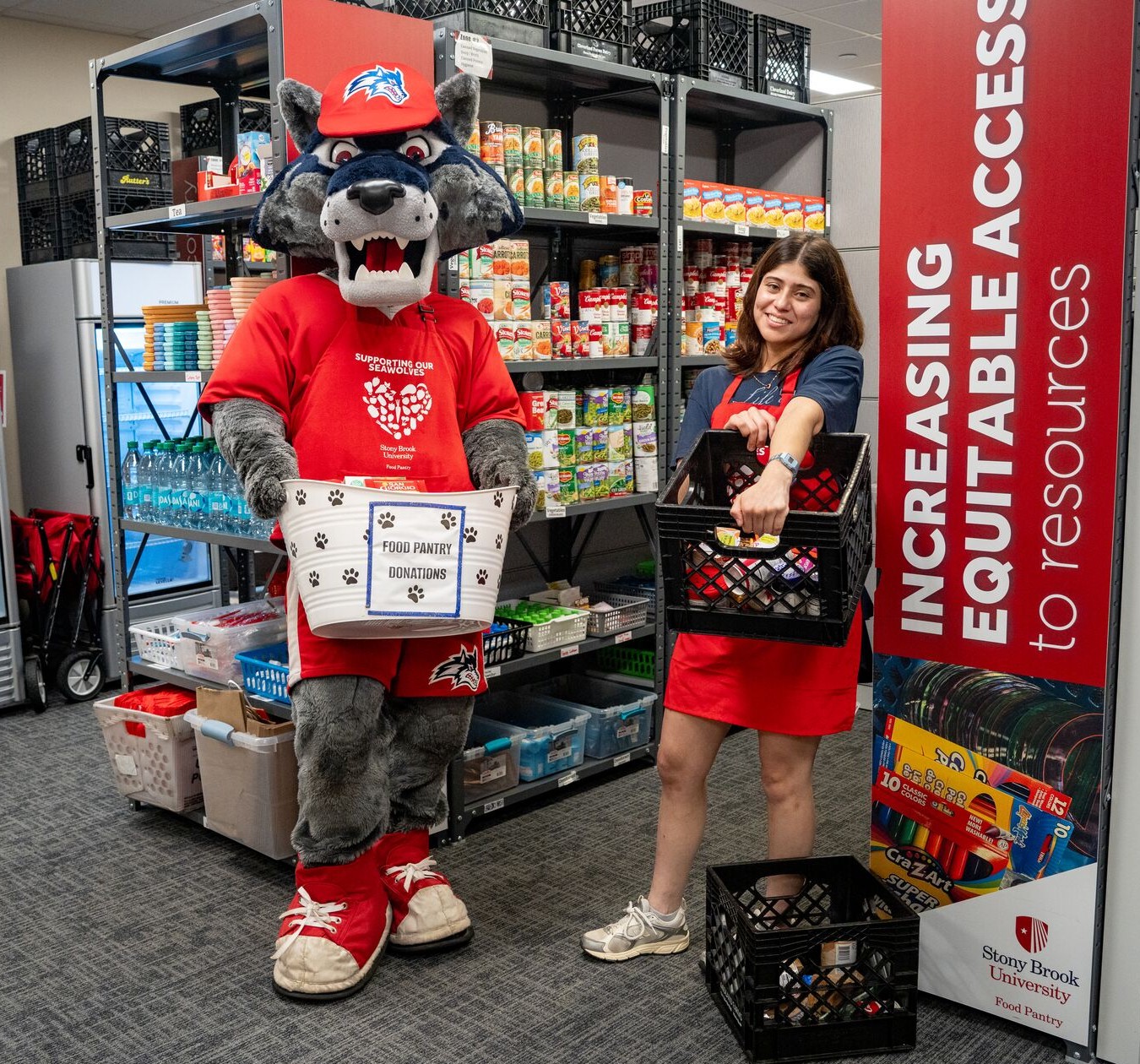 Stony Brook Wolfie mascot and student in the food pantry