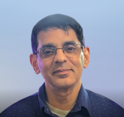 Guru Krupa wearing rectangle glasses and a navy shirt