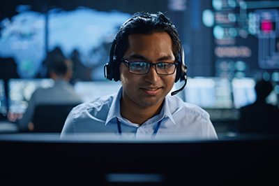 Man with headphones in front of computer
