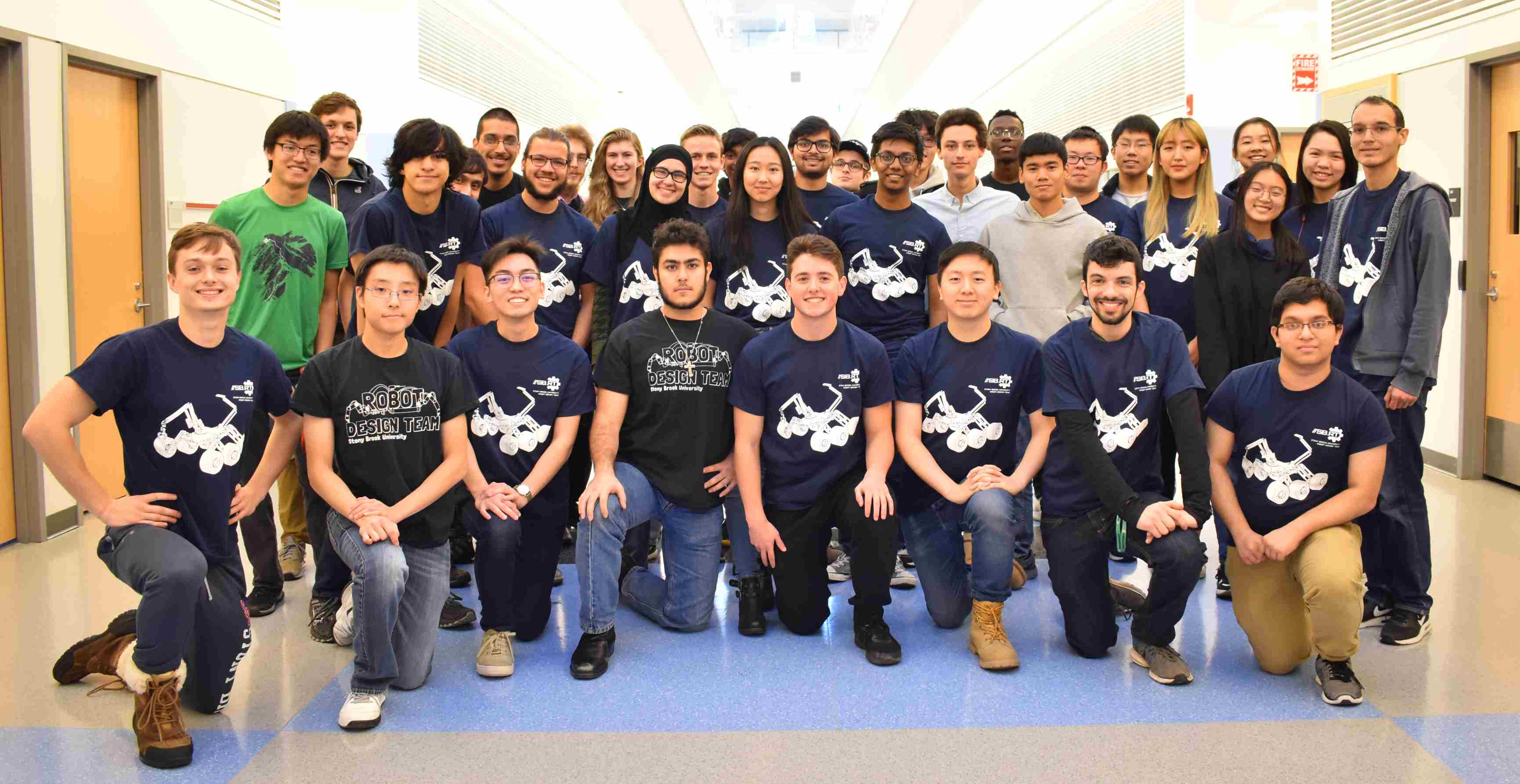 Group of students standing and kneeling for a group photo.