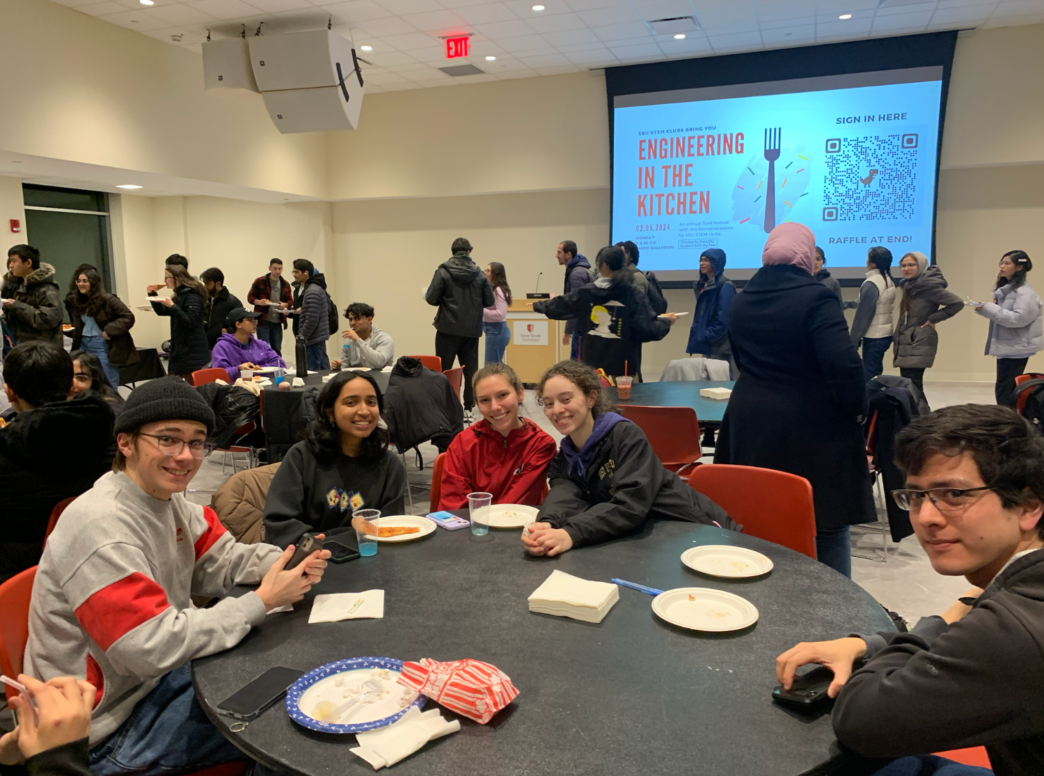 A group of people sitting at table, smiling.