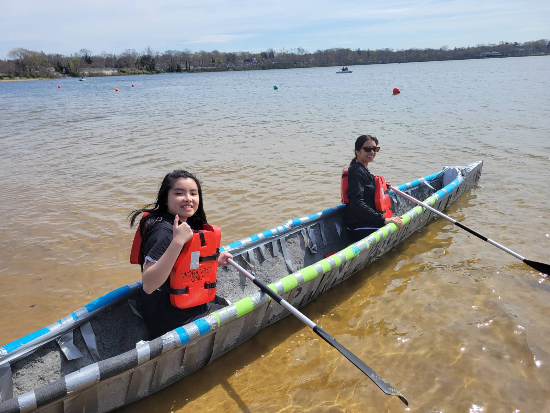 Two students sitting in a canoe made of concrete.