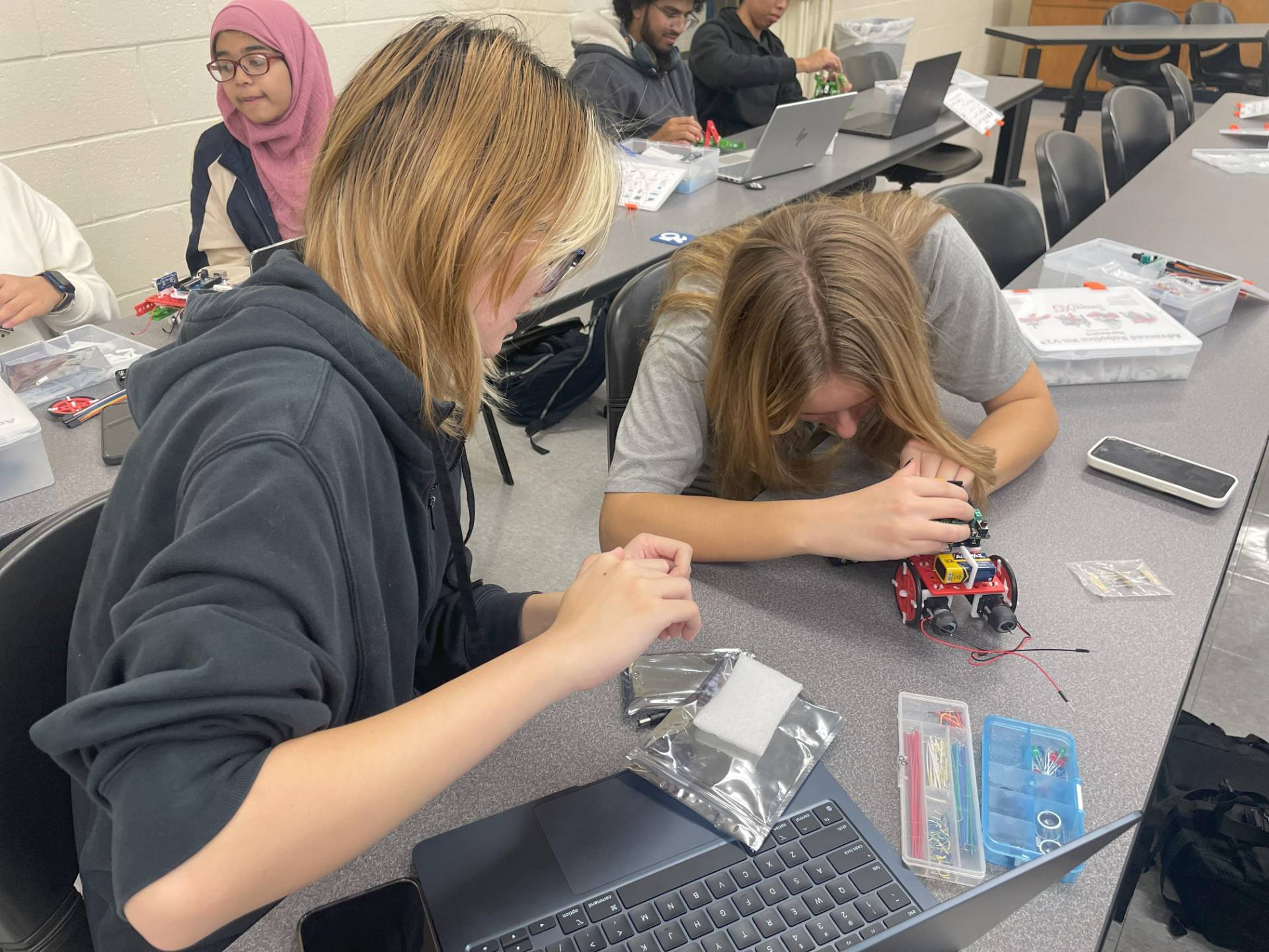 Two students working on a small device.