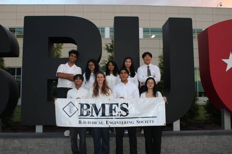 Student holds a sign that says Biomedical Engineering Society.