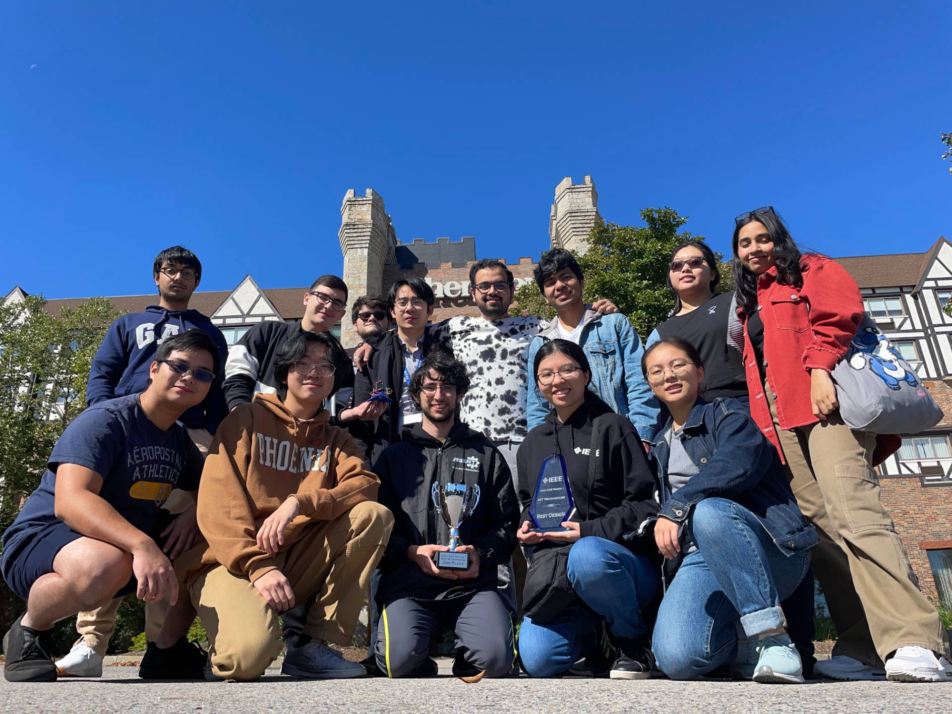 Group of students posing outside holding awards.