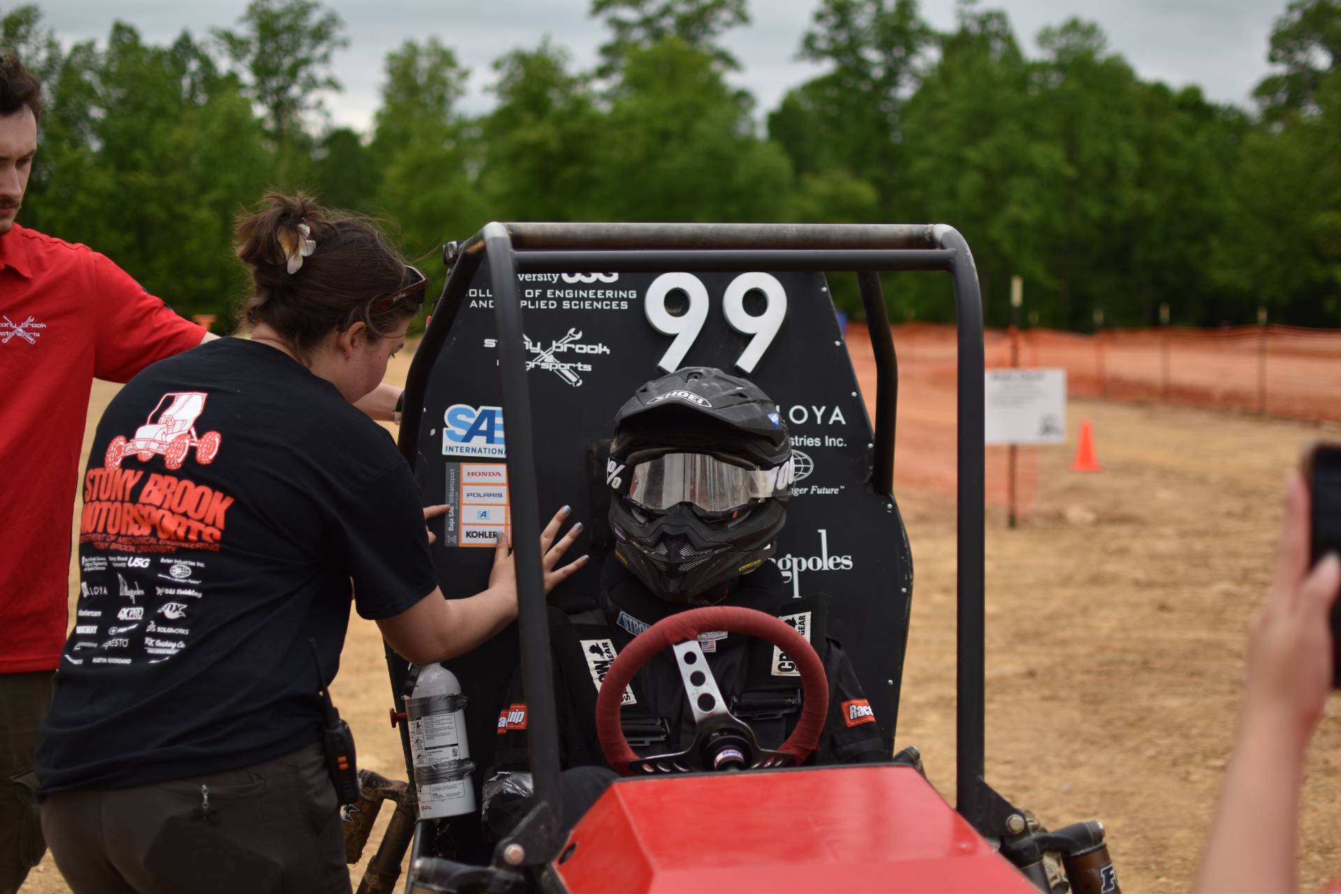 Person wearing a helmet sitting in an off-road vehicle.