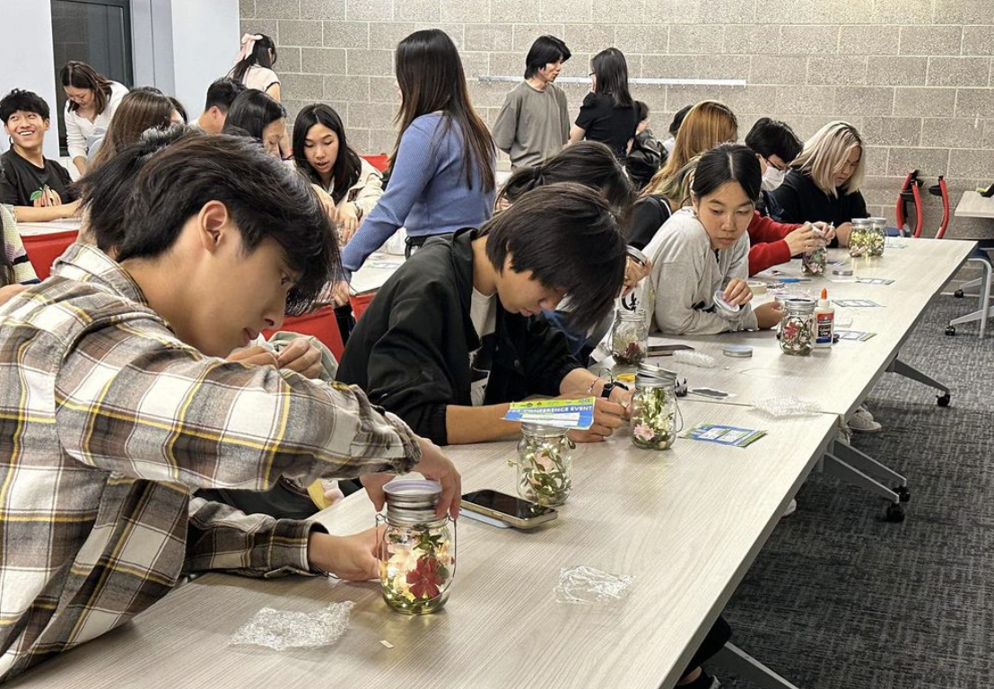 Students working at a table with arts and crafts.