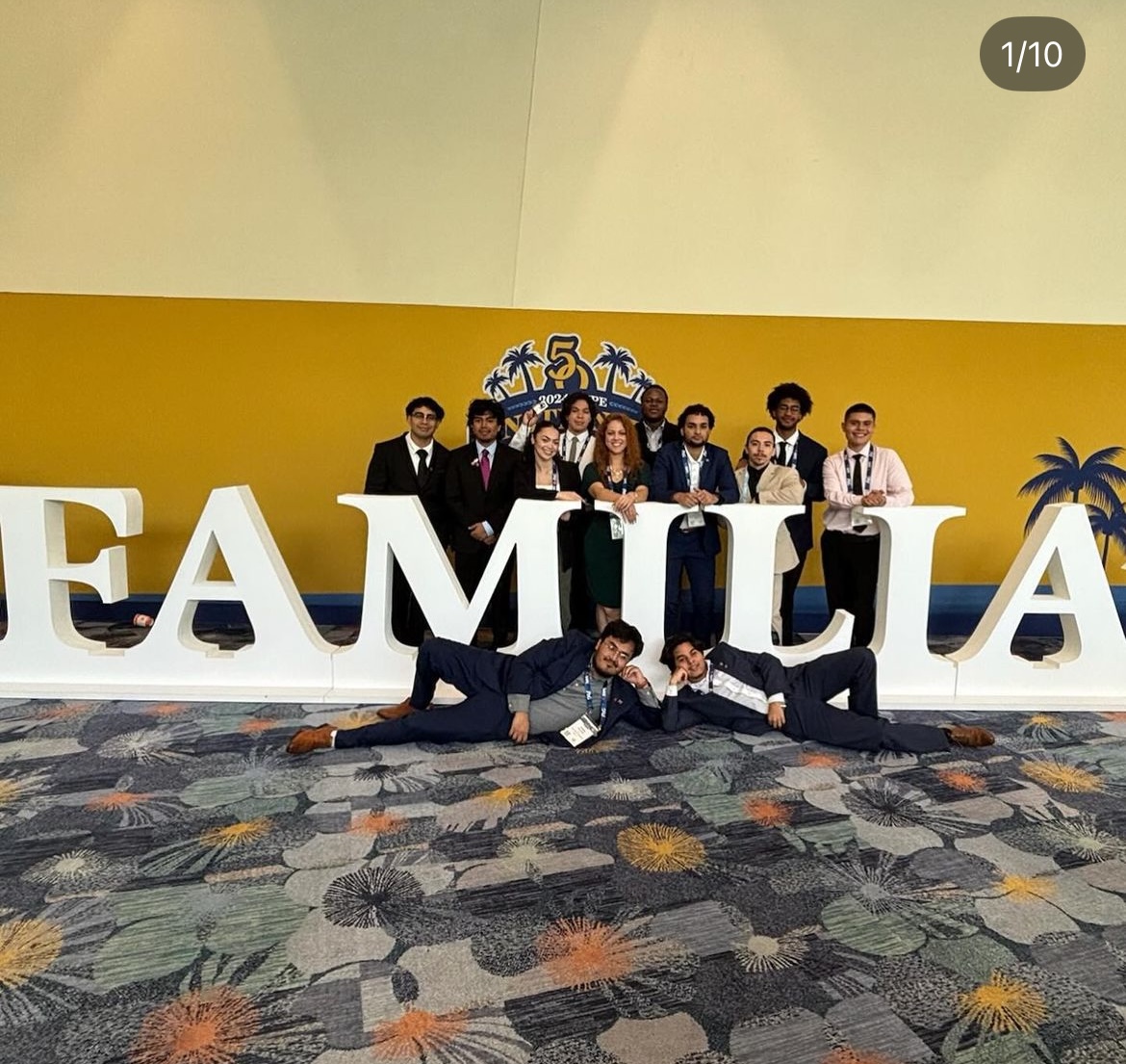 A group of students posing in front of a sign that reads Familia.