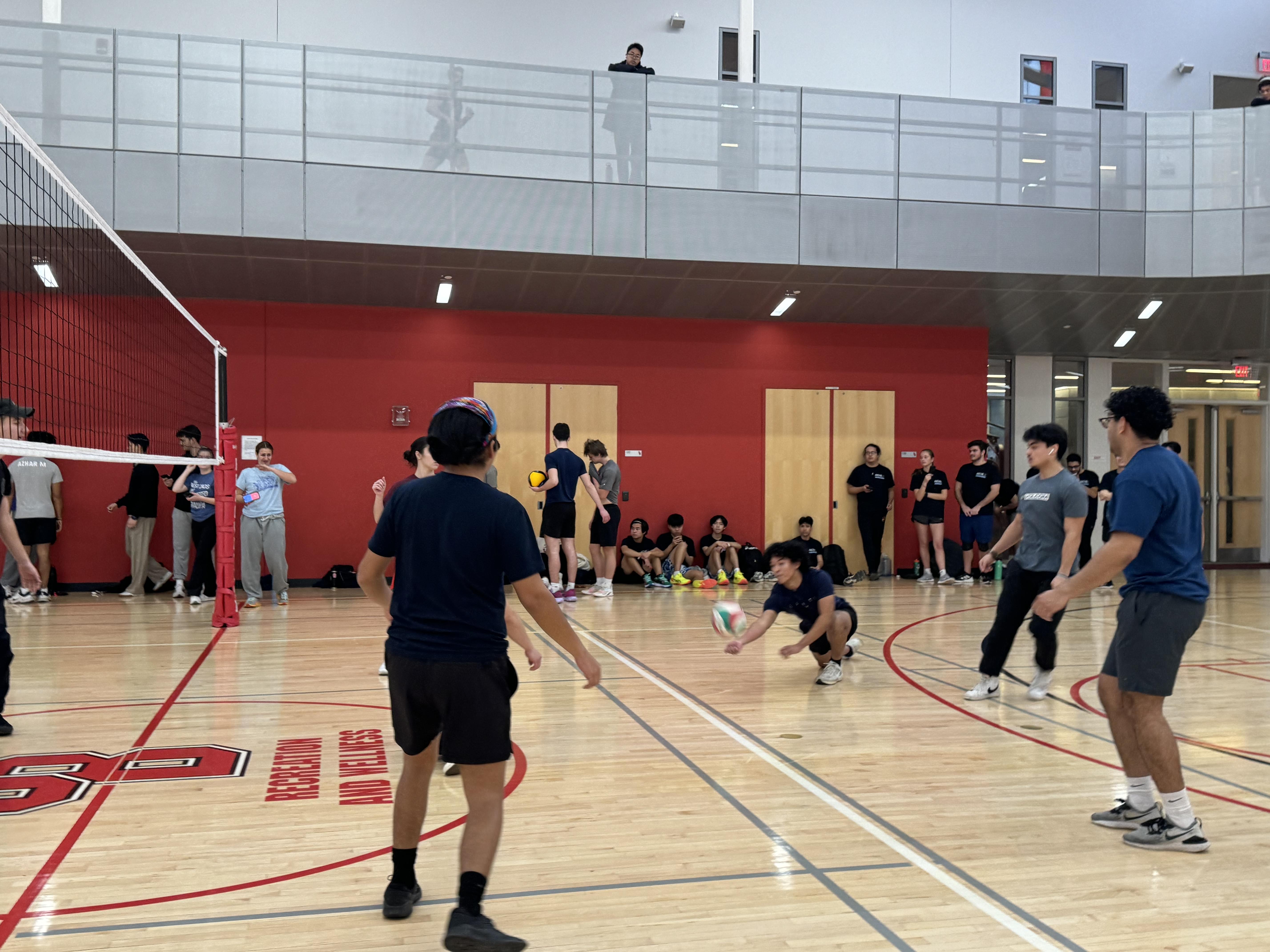 People playing volleyball on a court.