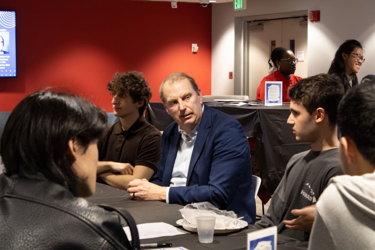 Students and panelists sitting at a table.