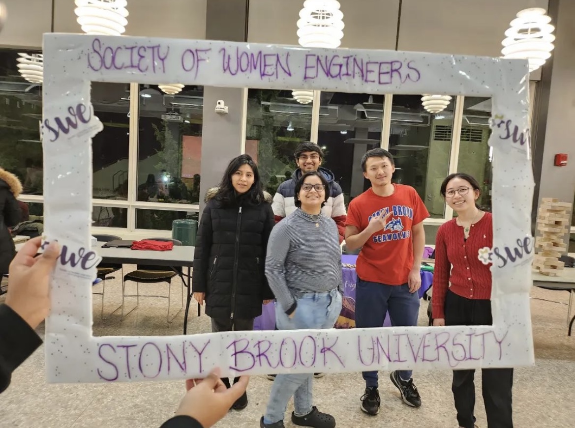 Students posing in a frame that says SWE Stony Brook University