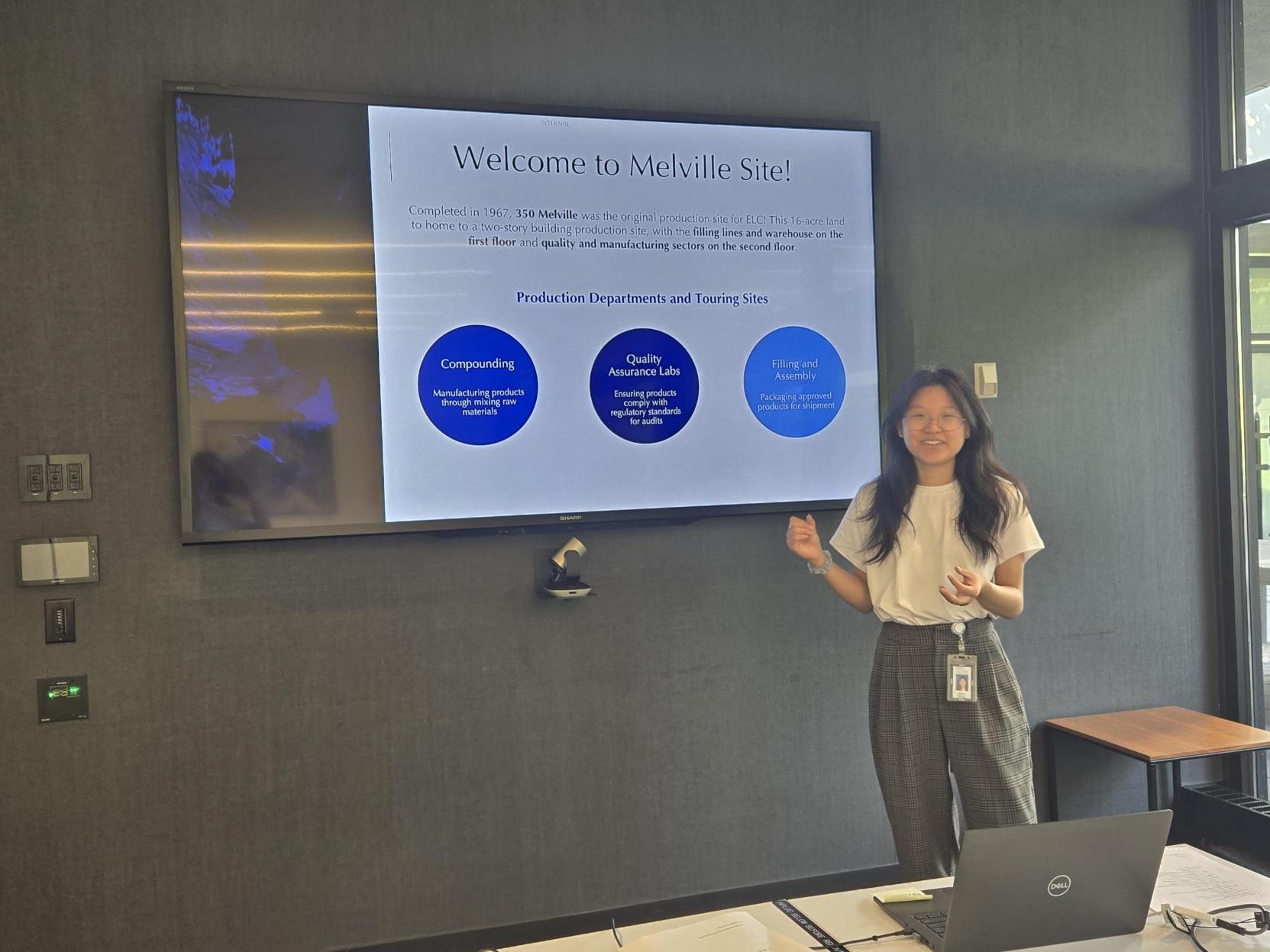 Anita smiling with a presentation on a screen behind her.